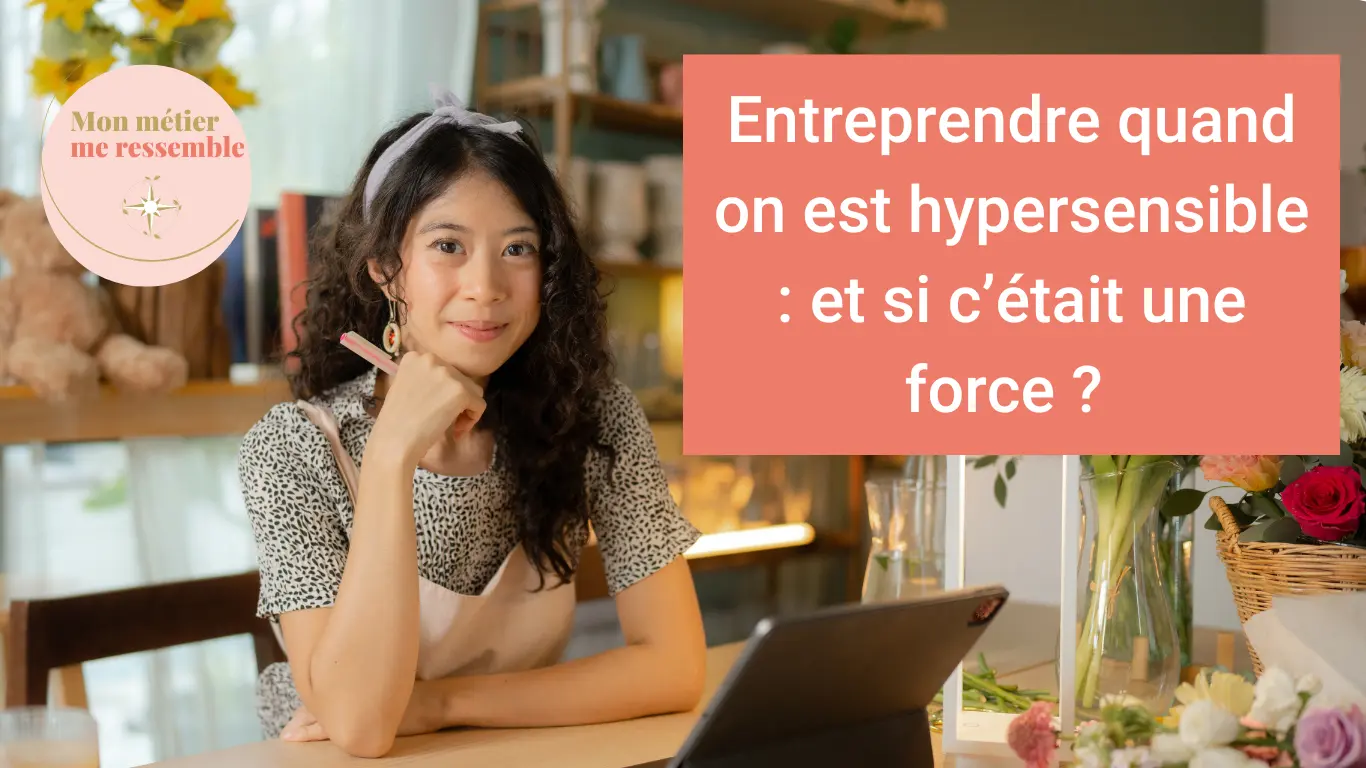 Une femme iinstallée à son bureau nous regarde avec un doux sourire, bannière article "entreprendre quand on est hypersensible : et si c'était une force ?